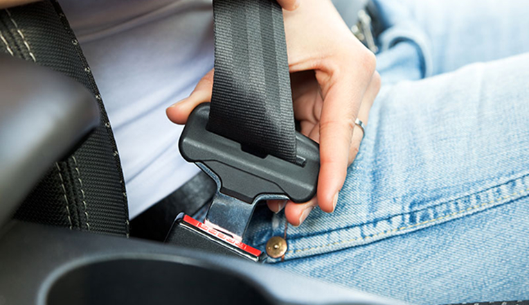 Person buckling a seat belt in a car